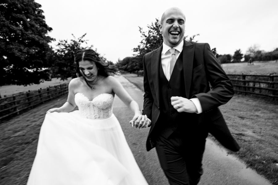 Couple running and laughing down a lane