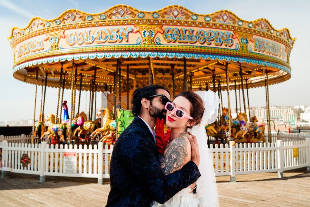 Couple in sunglasses by a seaside carousel