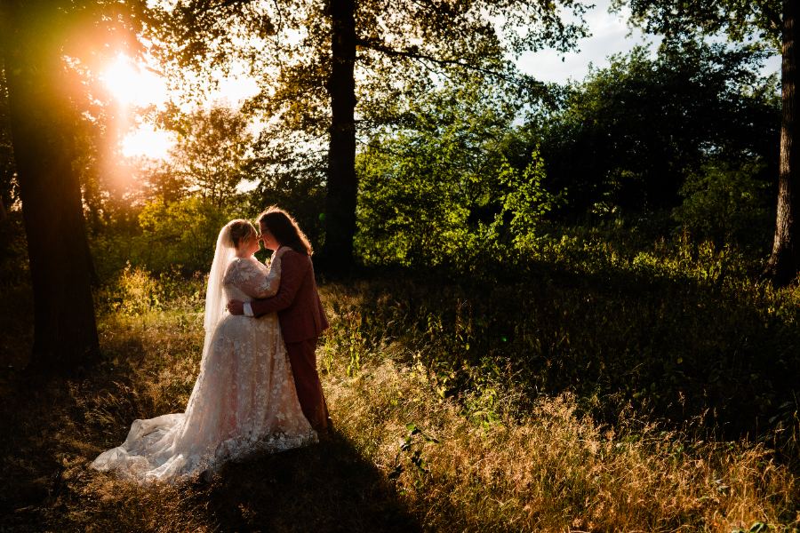 Couple in a sunlit woodland clearing at Evenley Wood Garden